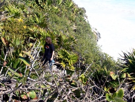 Travis climbing a rough trail up the cliff.