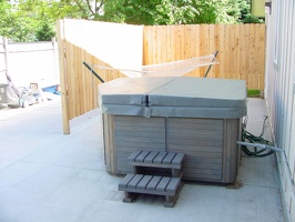 The new patio with hot tub and hammock.  New concrete, new fence, new porch light (upper right).