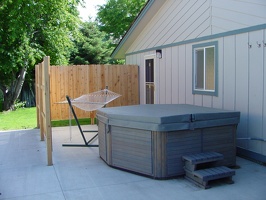 The new patio with hot tub and hammock.  New concrete, new fence, new door and screen door, new porch light.